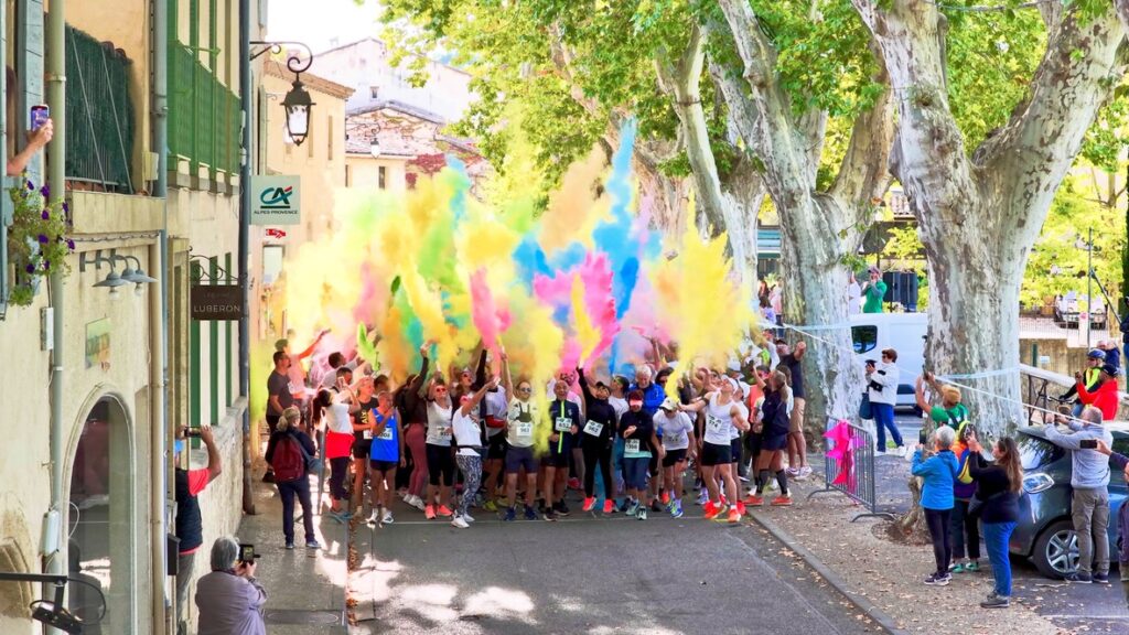 Coureurs et marcheurs réunis à Lourmarin sous un nuage de poudres colorées lors de la Color Run.